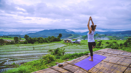 Freedom traveler woman relax in the holiday. Play if yoga Stand landscapes natural on the mountains and Field Rice.
