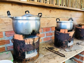 Aluminum pot on charcoal burning clay stove in local thai kitchen