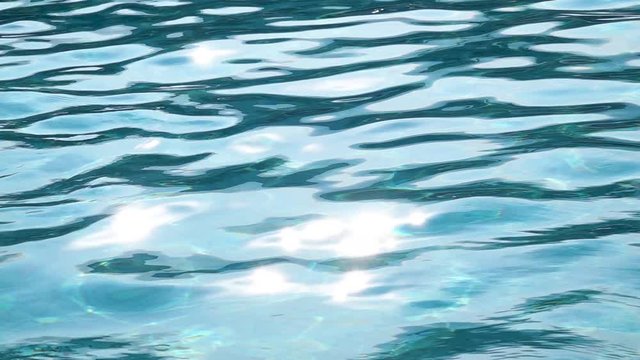 Turquoise water waves offshore with sun rays reflections. Slow motion. Close up
