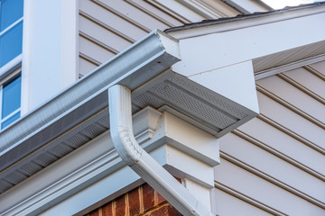 Close up of white frame gutter guard system,decorative trim,  eaves through, fascia, drip edge,...
