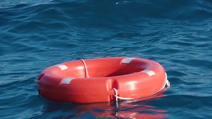 Life buoy or rescue buoy floating on sea to rescue people from drowning man. Slow motion. Close up