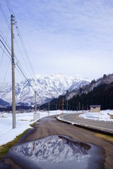 Obraz premium 霊峰を映す歩道の水たまりでのリフレクション