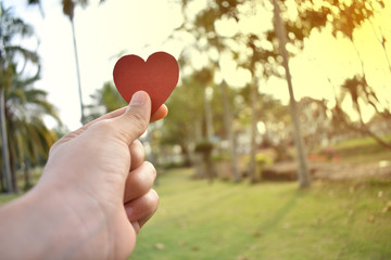 Concept heart shaped paper in hand at the festival of love