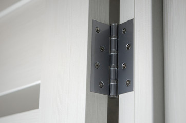 Metal door hinges close-up. Interior door with glass inserts