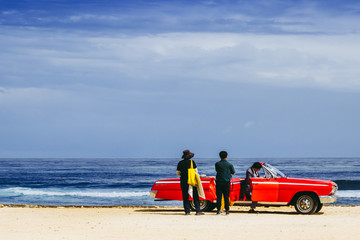 Old American car on the beach with people