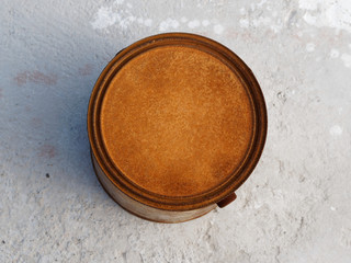 A rusty can of paint on concrete. Top veiw.