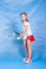 Young tennis player warming up before the game on a blue background. Tennis, reception, children’s sports.