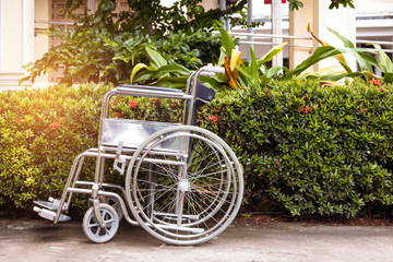 Fototapeta na wymiar Empty wheelchair in a garden of hospital waiting for patient services with copy space. 