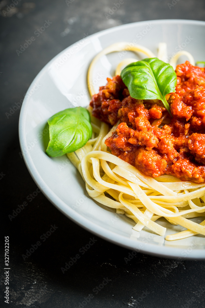 Wall mural traditional pasta bolognese with beef and tomatoes the rustic background. selective focus.