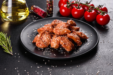 Chicken fillet in sesame seeds, teriyaki sauce on a black stone plate