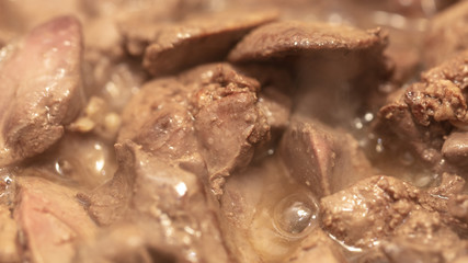 Chicken liver is fried in a pan.