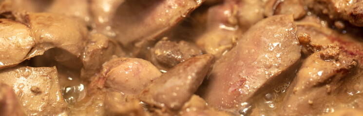 Chicken liver is fried in a pan.