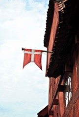 Danish flag (flag of Denmark) hangs from a red house in Den Gamle By (The Old Town), an open-air...