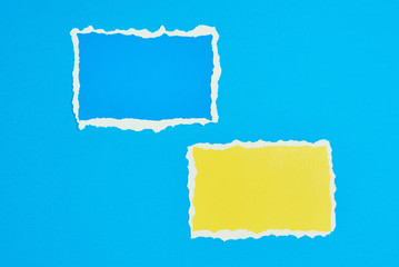 Two ripped paper torn edge sheets on a blue background. Template with piece of color paper