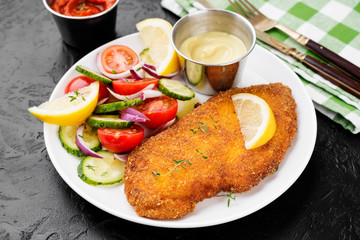 Homemade breaded chicken schnitzel with fresh vegetable salad. 
