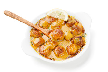 Homemade chicken meatballs in cheddar cheese sauce. isolated on white background