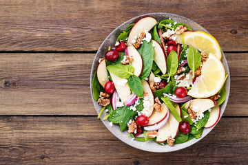 Homemade salad with fresh baby spinach, red apple, cranberry, walnuts and feta cheese.