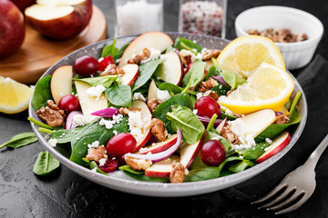 Homemade salad with fresh baby spinach, red apple, cranberry, walnuts and feta cheese.