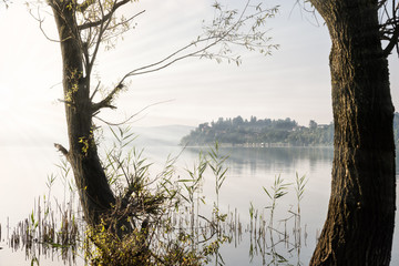 Italian lake with sunlight. Varese lake, northern Italy. Is frequented for fishing, rowing, walking...