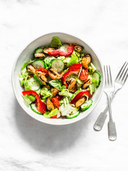 Salad with fresh vegetables and canned mussels on a light background, top view. Delicious healthy diet food