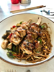 Japanese Food Bowl with Yakitori Chicken, Vegetable Noodles, Brussel Sprouts, Chili Pepper and Sesame.