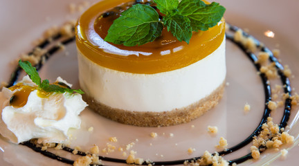 Tasty passion fruit cheese cake with mint leaves on top 
