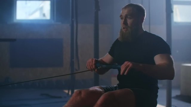 Slow motion: One rower trains in a fitness room on a rowing machine