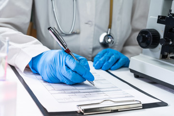 coronavirus 2019-nCoV virus,medical doctor 's hand holding blood sample and making notes writing...