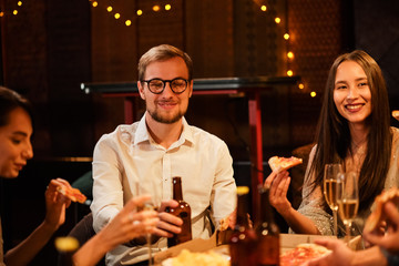 Happy group of friends at the bar having drinks.