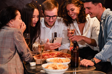 Happy group of friends at the bar having drinks.