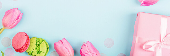 View from above tulips and gift box with copy space on blue. Background for womens day, 8 March Valentine's day, 14 february. Flat lay style, top view, mockup, template, overhead. Greeting card