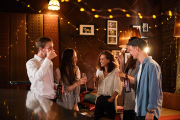 Happy group of friends at the bar having drinks.
