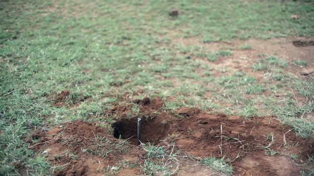 Installation of a metal land beacon marker, medium shot