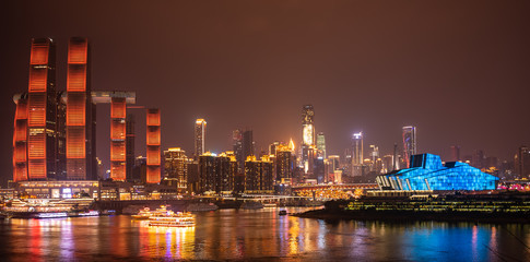 Night long exposure of Chongqing cityscape. Reflection of the skyscrapers and modern buildings in the water of Yangtze river. Landscape panoramic view of downtown in developed Chinese metropolis city.