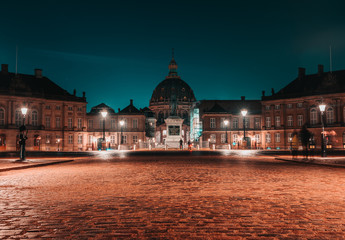Night long exposure panoramic view after rain of Amalienborg winter residence 18th-century rococo complex of palaces with museum & marches/displays by royal guards in Copenhagen, Denmark. 