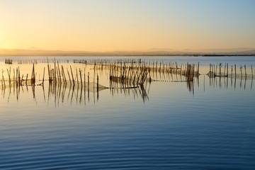 Fototapeta na wymiar the sunset with fishing nets on a lake