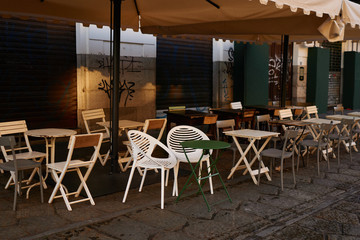 Terrace of small cafe in Europe with tables with different chairs