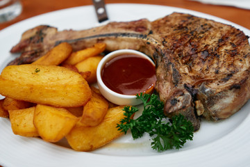 Delicious fried potatoes with beef steak and ketchup on a plate served in restaurant