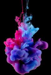 Colors ink splashing in water isolated on black background.