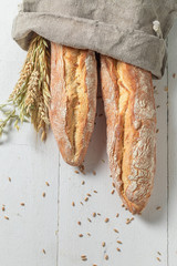 Crunchy golden baguettes freshly baked in linen bag