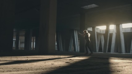 Woman doing shadow boxing workout in urban area. Real speed action shot with sunlight in background.