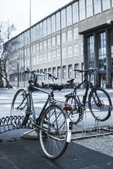 Fototapeta na wymiar vertical shot of vintage bicycles in front of university building in Cologne, Germany