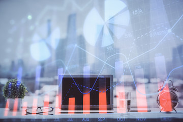 Forex graph hologram on table with computer background. Multi exposure. Concept of financial markets.