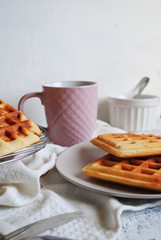 Delicious waffles on a plate, jam and a cup of coffee