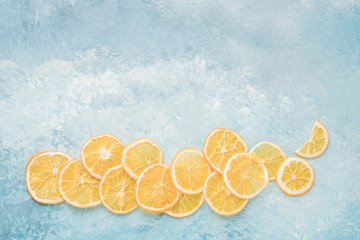dried orange slices on blue background with copy space