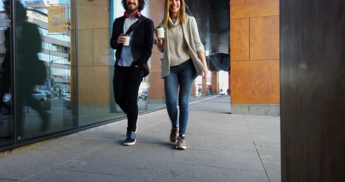 Two young business people walking on the way to building