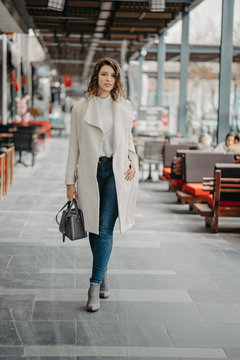 Beautiful young brunette girl walking on the restaurants street of the city
