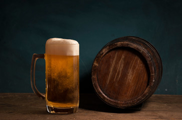 Old oak barrel on a wooden table. Behind blurred dark background.