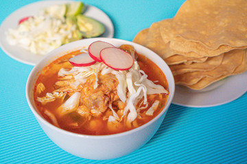 Delicious typical Mexican red Mexican pozole with tostadas