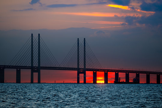 Oresund Bridge between Denmark and Sweden, Oresundsbron. Sunset landscape view whit passing ship under the bridge. Malmo to Copenhagen.